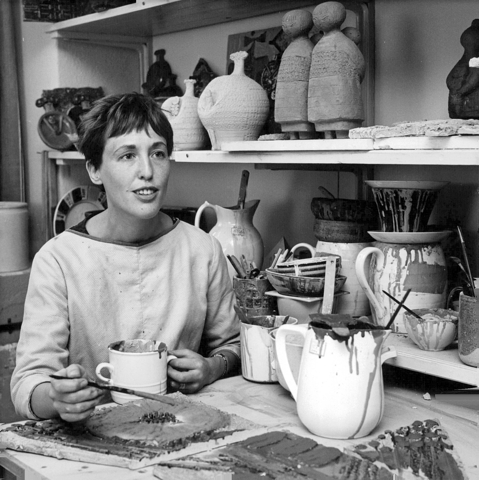 工房の机で陶板に筆を入れる Lisa Larson。1969年